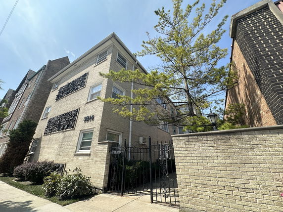 Front view of a multi-story brick building with decorative window covers.