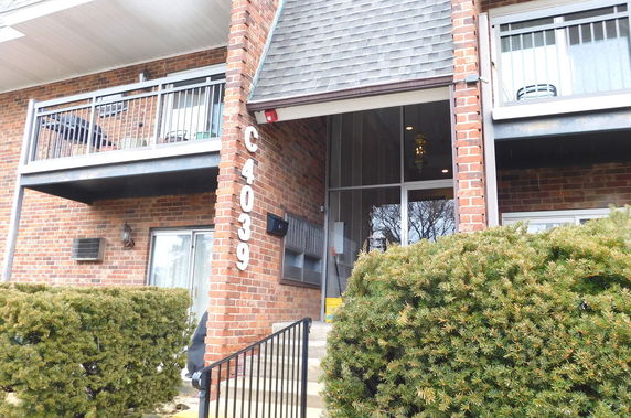 Front view of a brick apartment building with balconies.