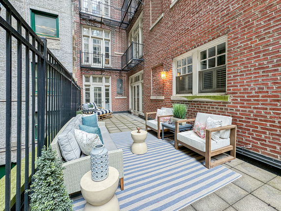Rooftop patio with seating area on a brick building.