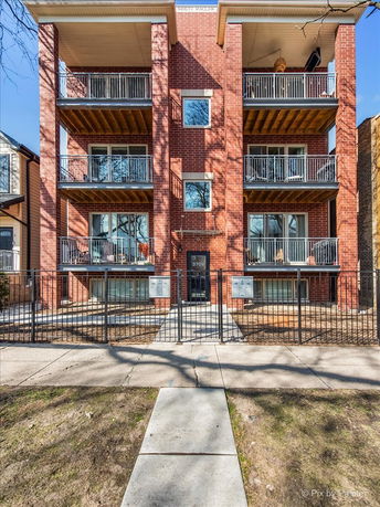 Front view of a multi-story brick building with balconies.