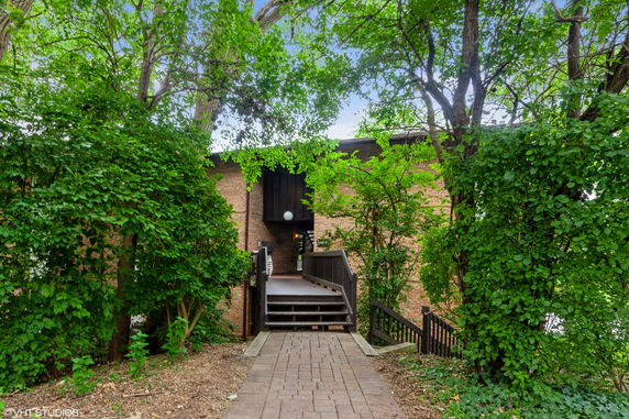 Front view of a building with brick façade and surrounding trees.