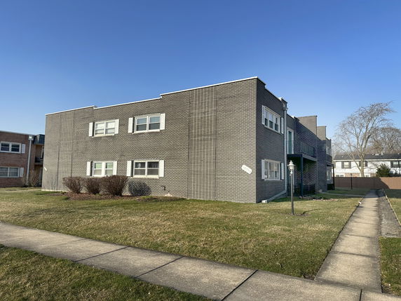 Front view of a two-story brick building with multiple windows.