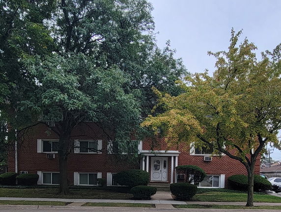 Front view of a two-story brick building with multiple windows and a central entrance.