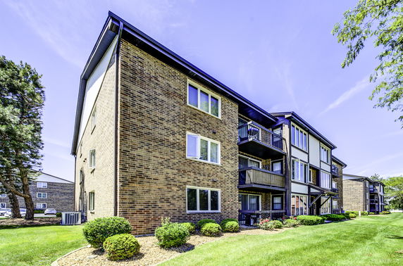 Front view of a multi-story apartment building with balconies.
