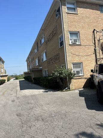 Side view of a three-story brick apartment building.