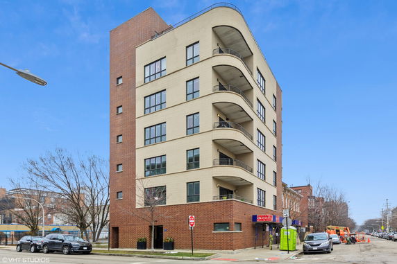 Front view of a multi-story building with rounded balconies.