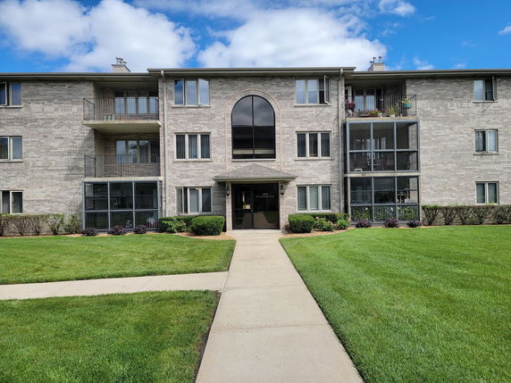 Front view of a multi-story apartment building with balconies.