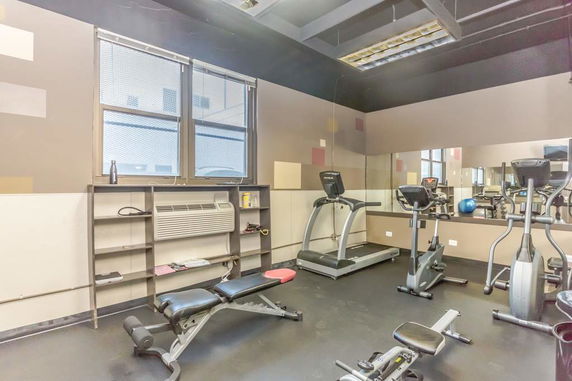 Indoor gym area with exercise equipment including treadmills and stationary cycles.