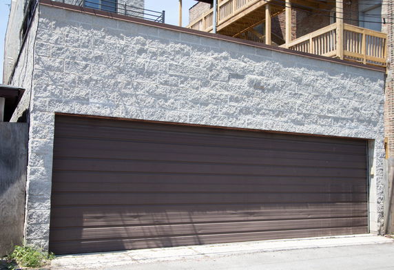 Front view of a building with a large brown garage door.