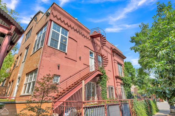 Front view of a two-story brick building with a spiral staircase.