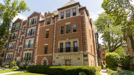 Front view of a multi-story brick building with decorative stone elements.