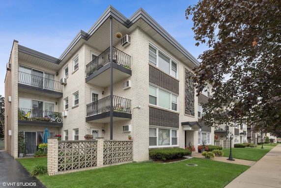 Front view of a multi-story apartment building with balconies.