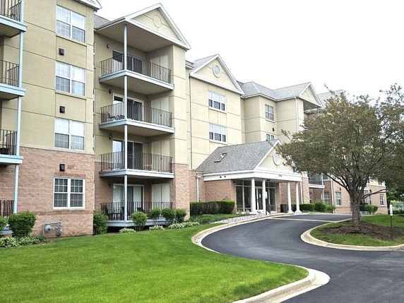 Front view of a multi-story residential building with balconies.