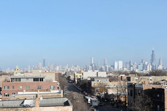Panoramic view of city skyline with numerous skyscrapers under a clear blue sky.