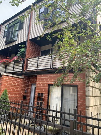 Front view of a multi-story building with balconies and brick exterior.