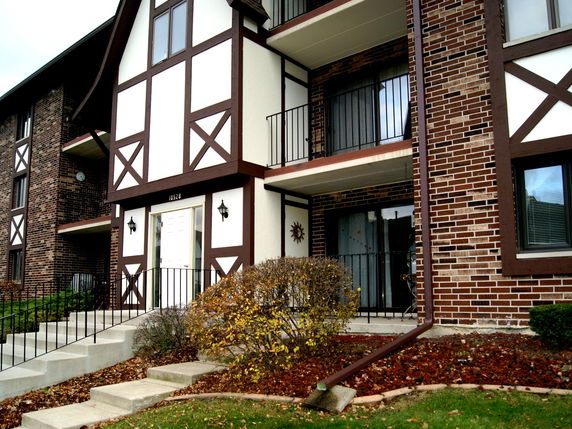 Front view of a multi-story building with brick and panel facade.
