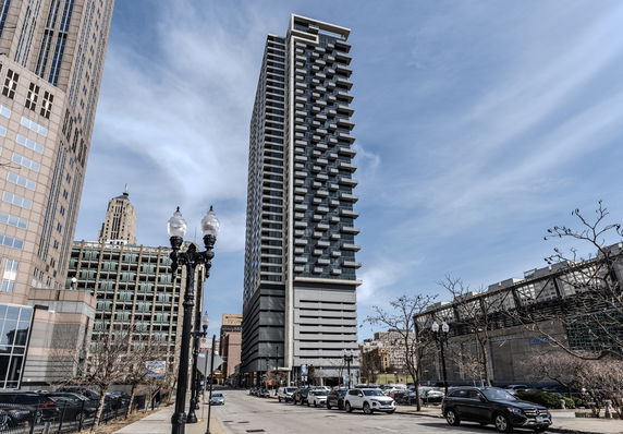 Front view of a tall residential building with multiple balconies.