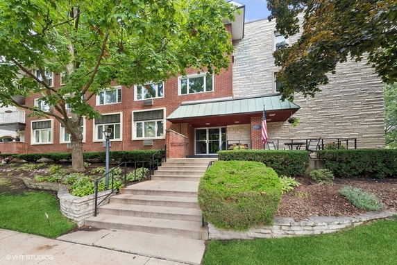 Front view of a multi-story brick and stone building with a staircase leading to the entrance.