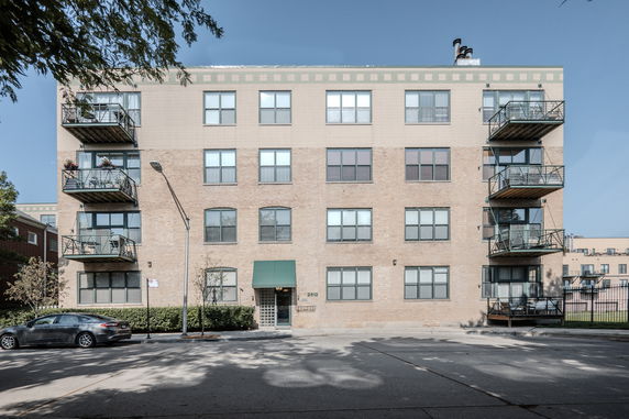 Front view of a multi-story apartment building with balconies.