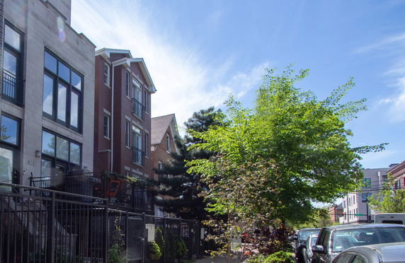 Front view of multi-story residential buildings with large windows and brick exterior.