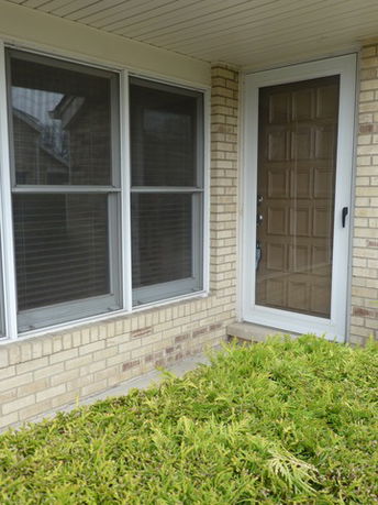 Front view of a building with large windows and a glass-paneled door.