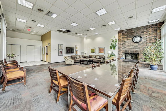 Spacious clubhouse interior with seating area and large table.