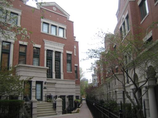 Front view of a multi-story brick building with large windows and steps leading to the entrance.