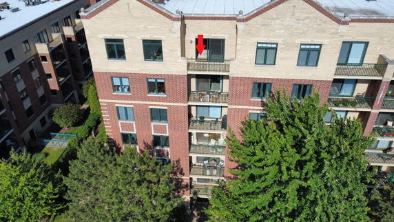 Front view of a multi-story brick apartment building with balconies.