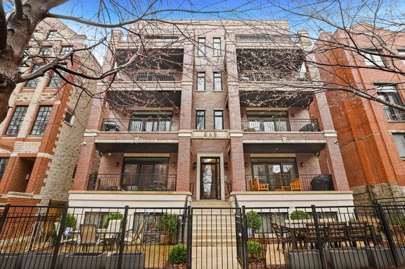 Front view of a multi-story brick building with balconies.