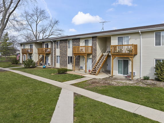 Front view of a two-story apartment building with exterior balconies and staircases.