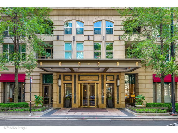 Front view of a multi-story building entrance with large windows and a polished facade.