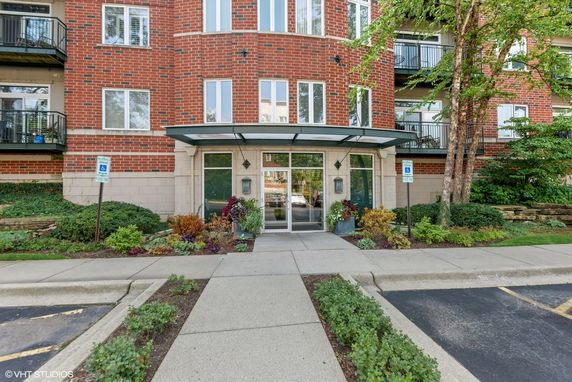 Front view of a multi-story brick building with a glass entrance.
