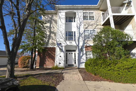 Front view of a multi-story building with brick and siding exterior.