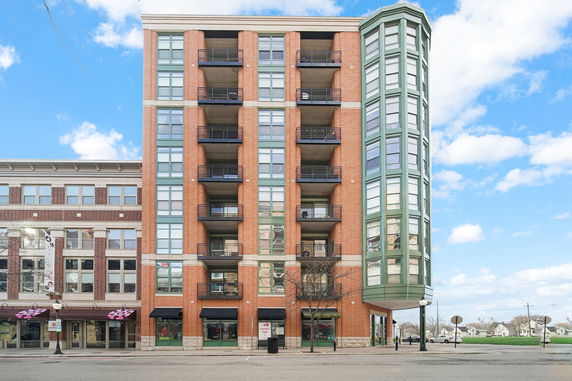 Front view of a multi-story brick building with balconies.