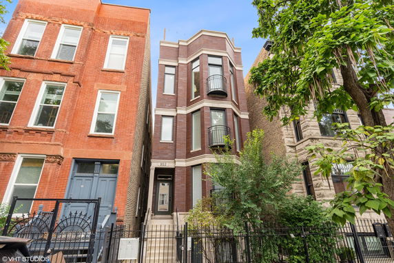 Front view of a multi-story brick building with balconies.