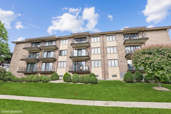 Front view of a multi-story apartment building with balconies.