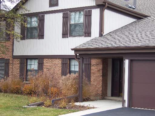 Front view of a two-story house with brick and siding exterior and an attached garage.