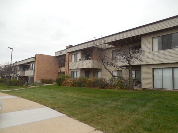 Front view of a multi-story apartment building with balconies.