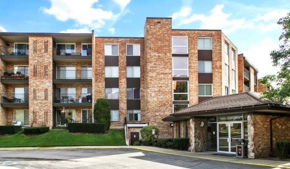 Front view of a multi-story brick building with balconies.