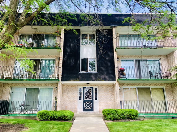Front view of a three-story apartment building with balconies.