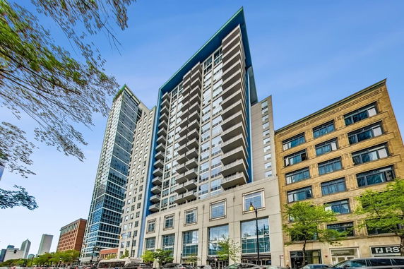 Front view of a modern high-rise residential building with balconies.
