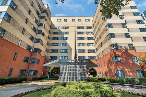 Front view of a multi-story apartment building with brick and concrete exterior.