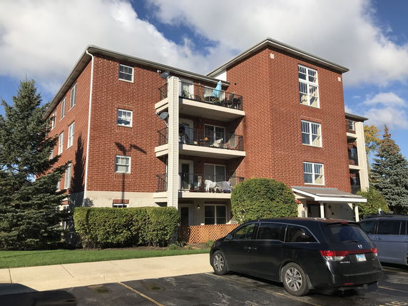 Front view of a multi-story brick apartment building.