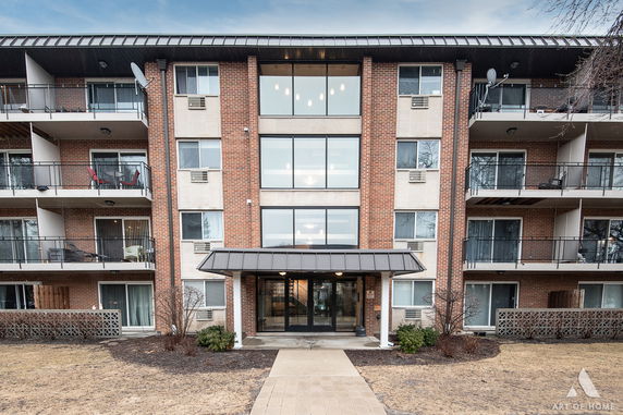 Front view of a multi-story apartment building with balconies.