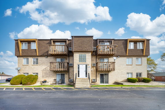 Front view of a multi-story residential building with balconies.