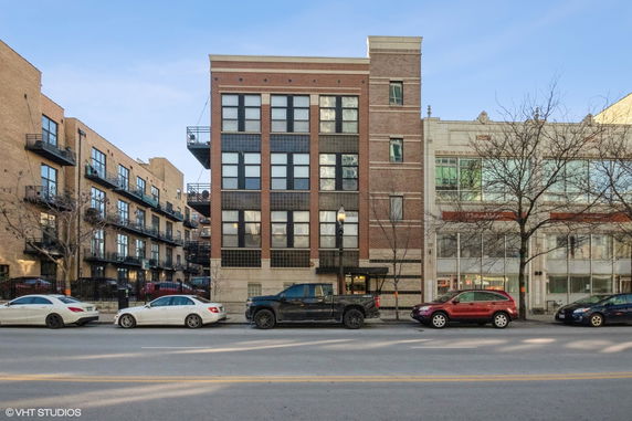 Front view of a multi-story brick building with large windows and balconies.