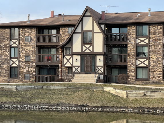 Front view of a multi-story building with Tudor-style architecture and balconies.