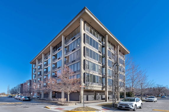 Front view of a multi-story building with large windows and a flat roof.