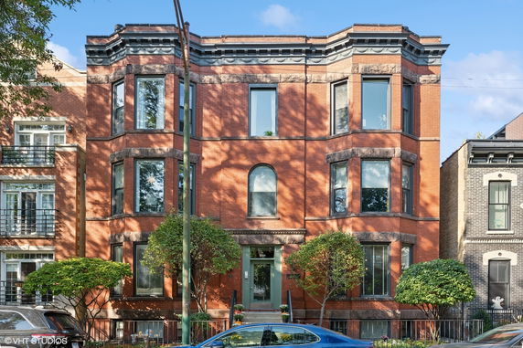 Front view of a multi-story brick building with large windows and decorative stone accents.