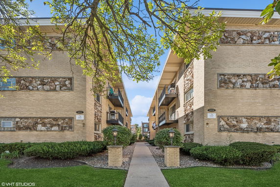 Front view of apartment buildings with balconies and stone facade accents.